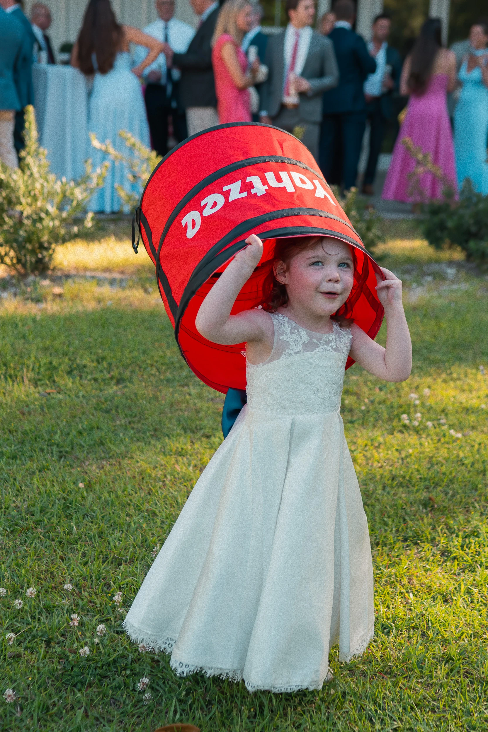 Flower girl laughing and wearing a yahtzee bucket