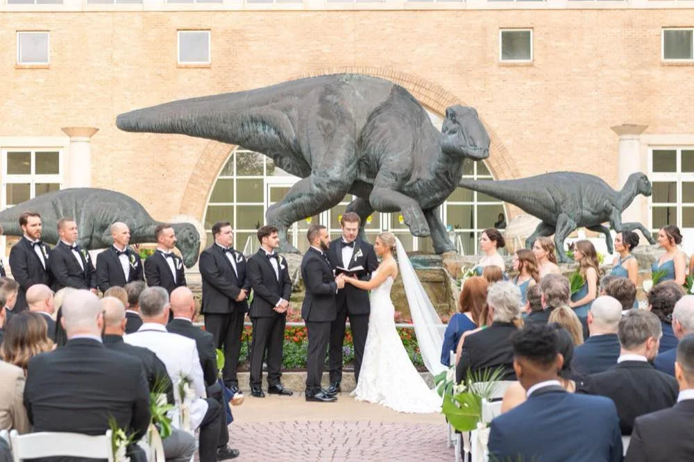 Wide film photo of bride and groom in front of the Fernbank Museum